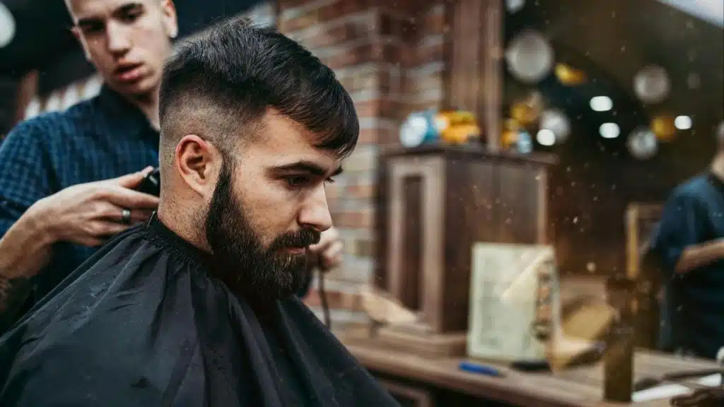 A man getting a haircut at a barbershop.