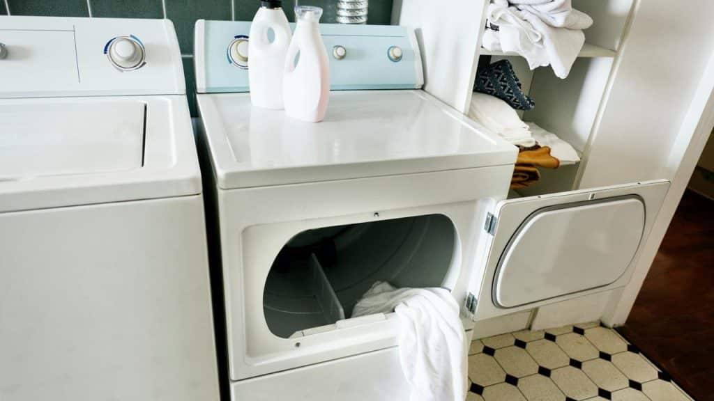 A laundry room with a washer, dryer, and cleaning supplies.