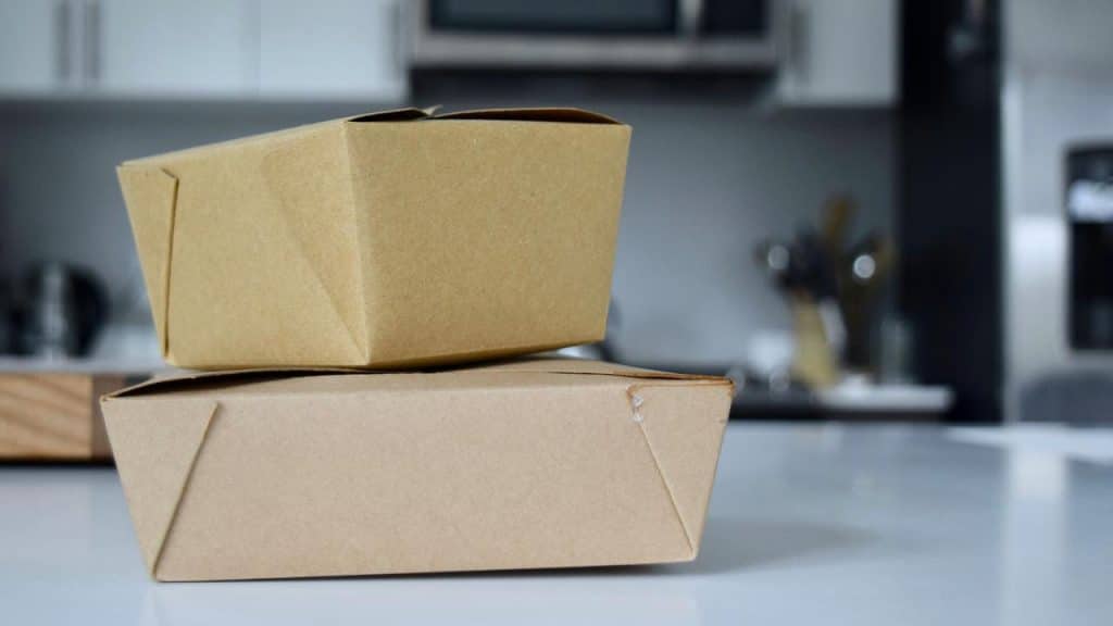 A pair of stacked brown takeout food containers on a counter.