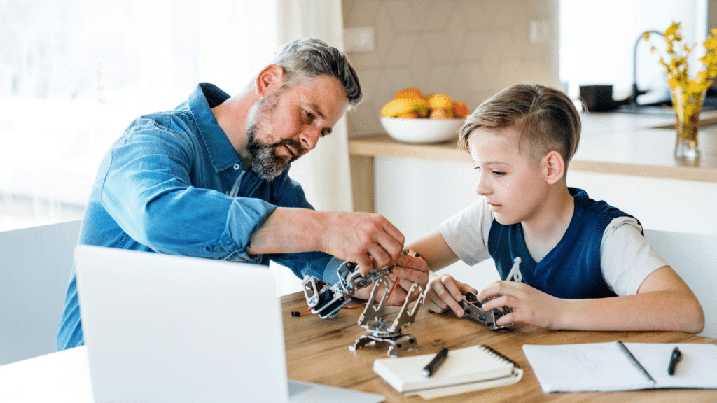 Father and son working together on a small robotics project at a kitchen table.