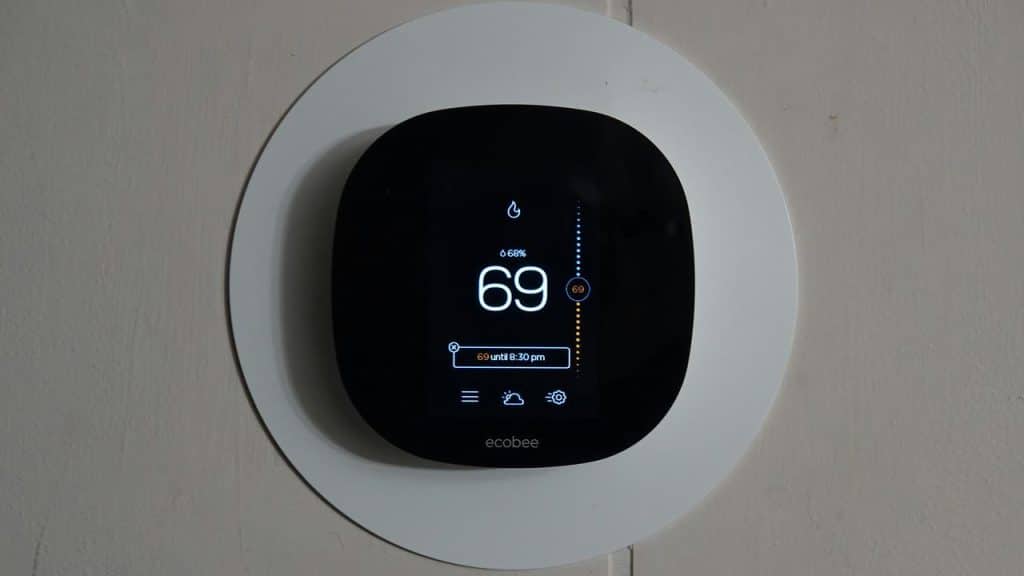 A smart thermostat displaying a temperature of 69 degrees.