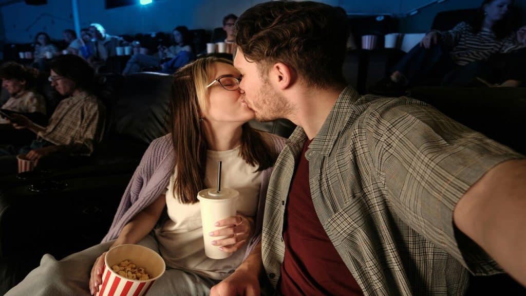 A couple kissing while watching a movie