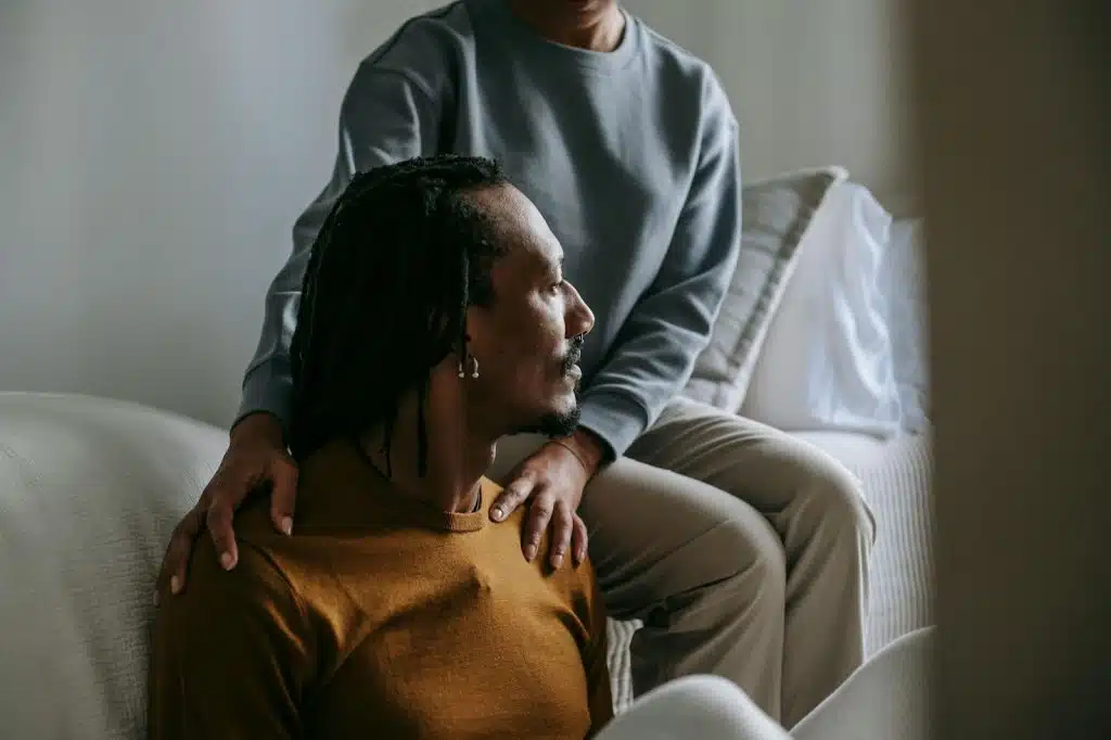 A woman holding man’s shoulder