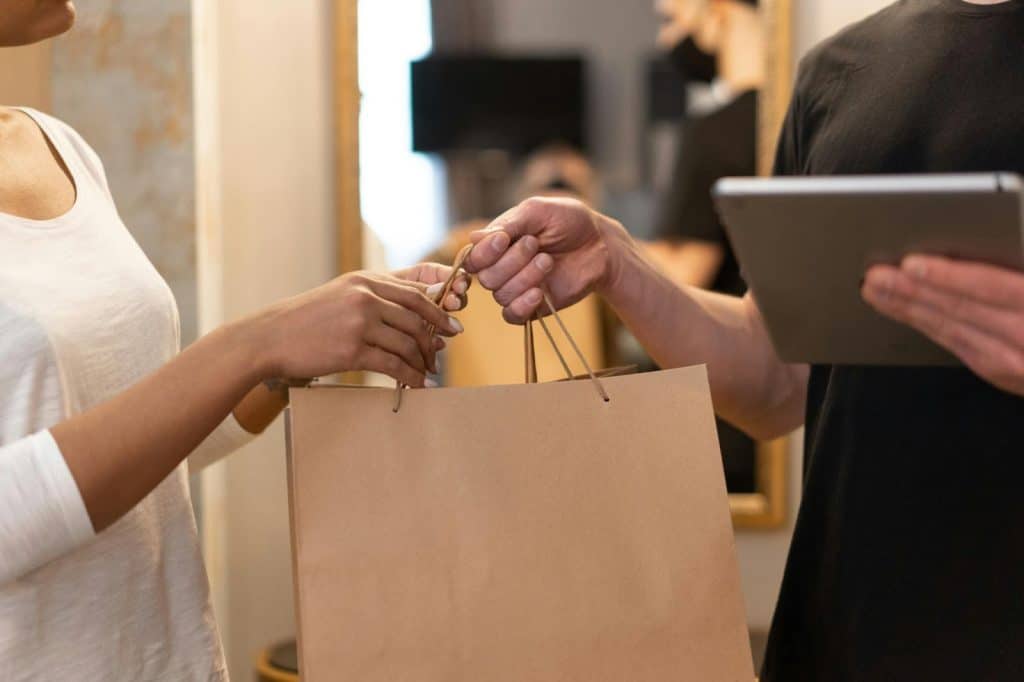 A man giving a paperbag to woman