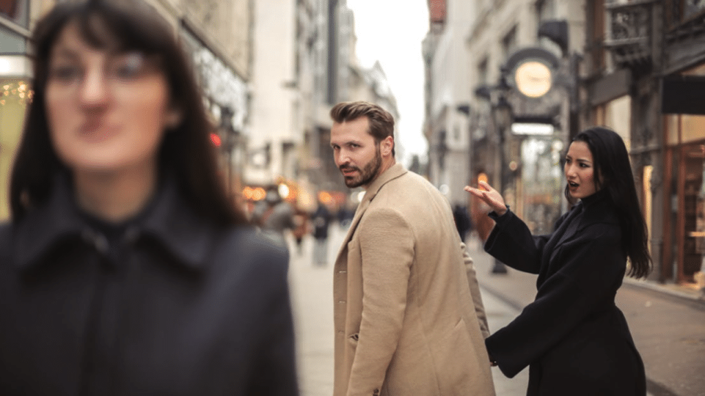 A man looking at another woman while he’s with his girlfriend