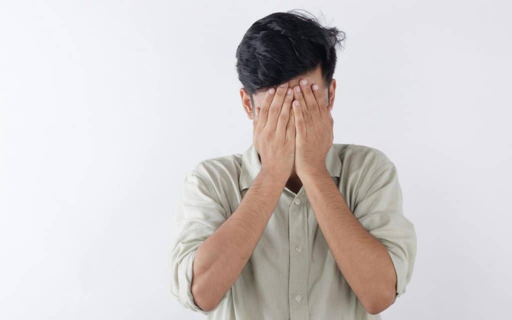 A man covering his face