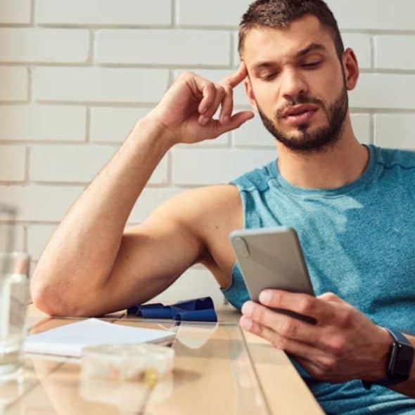 Man repeatedly texting his partner, looking anxious
