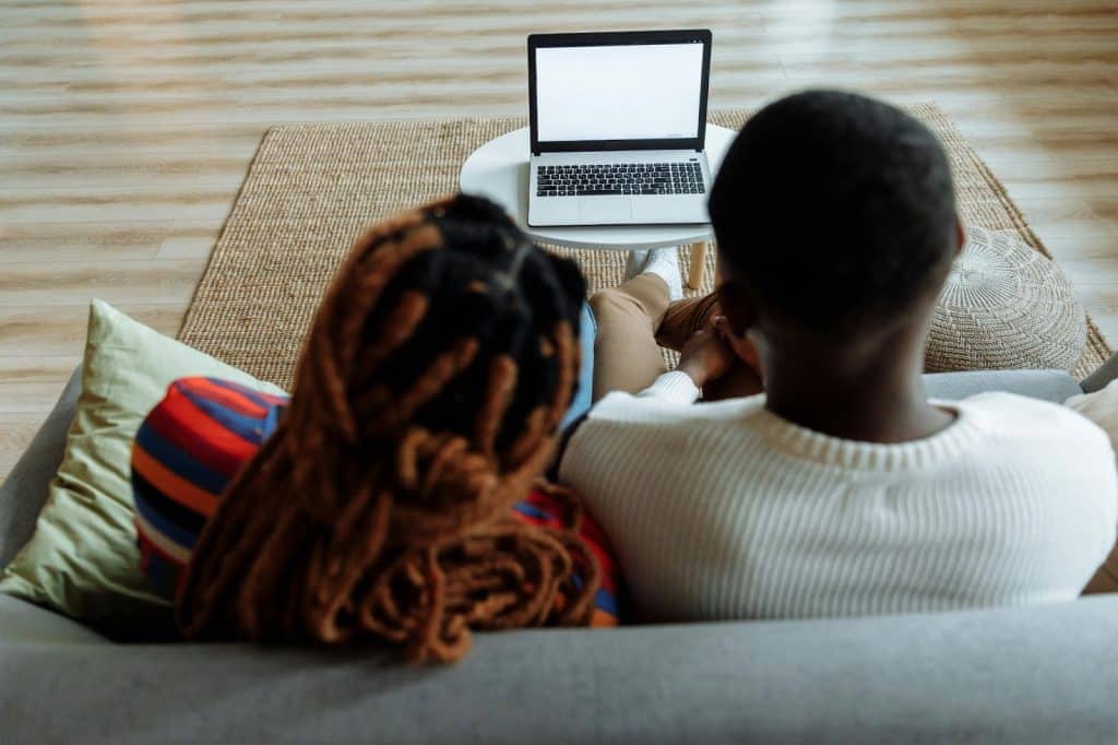 A man and woman facing the laptop