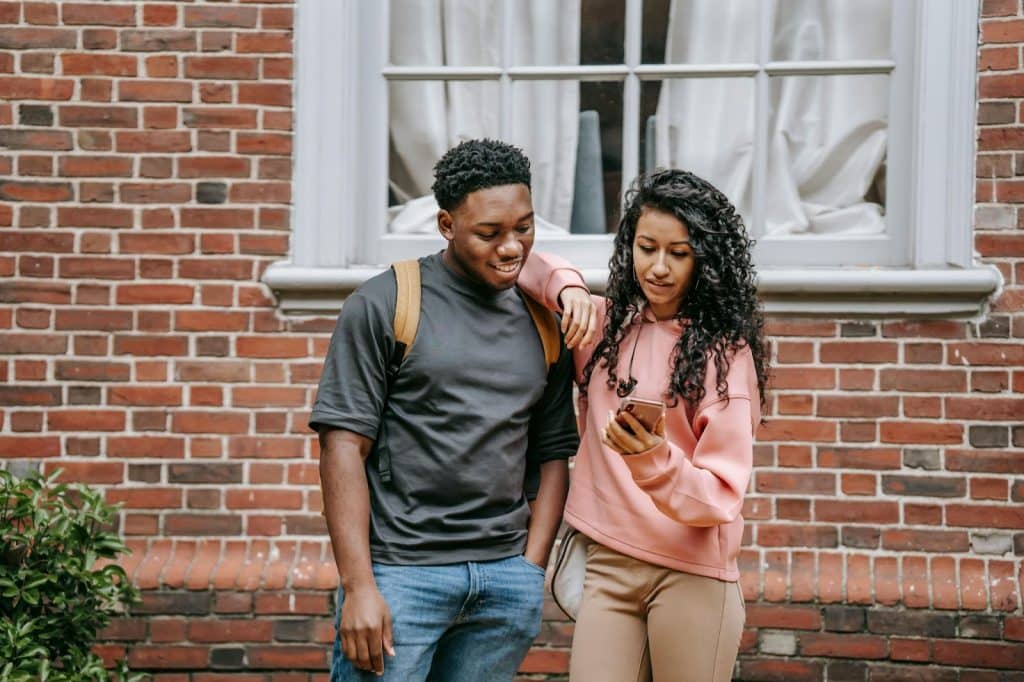 A man and woman looking at the phone