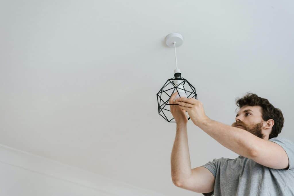 A man changing a light bulb at home