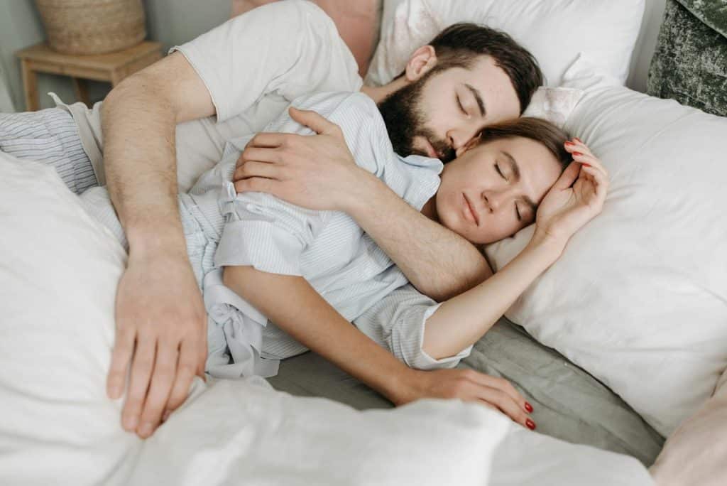 A man embracing a woman while sleeping