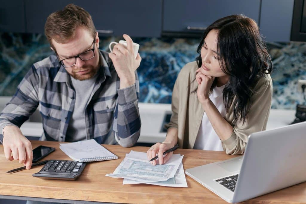 A man calculating expenses with woman