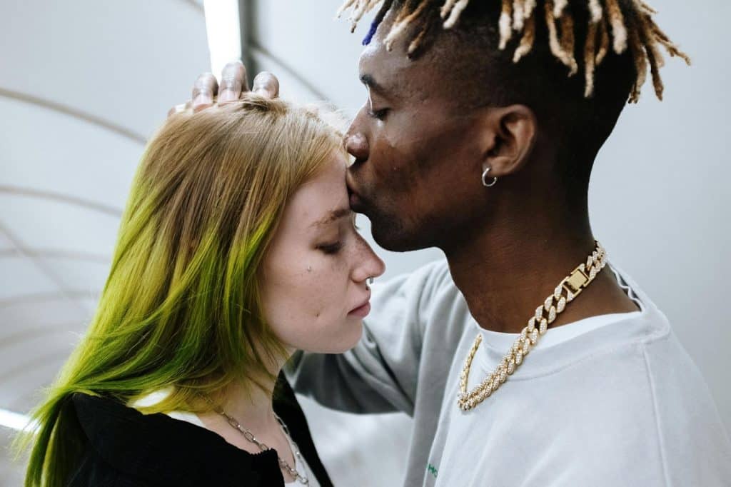 A man kissing a woman’s forehead