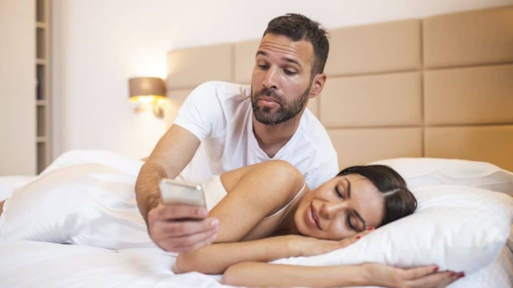 Man scrolling through his partner’s phone suspiciously