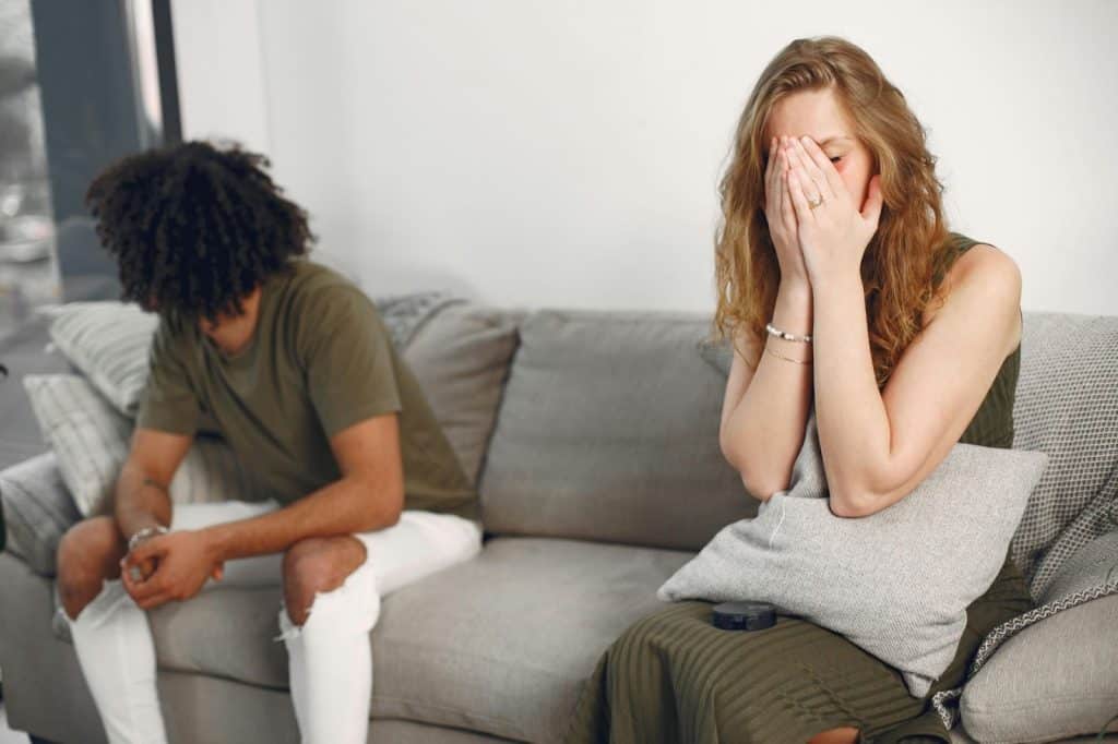 A man and woman sitting away from each other