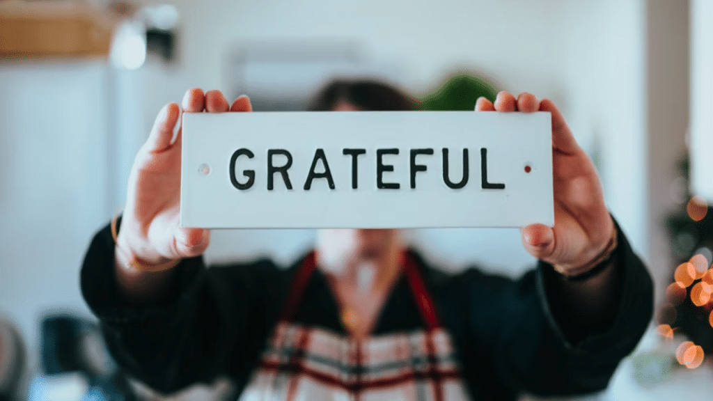 A person holding a sign saying “grateful”