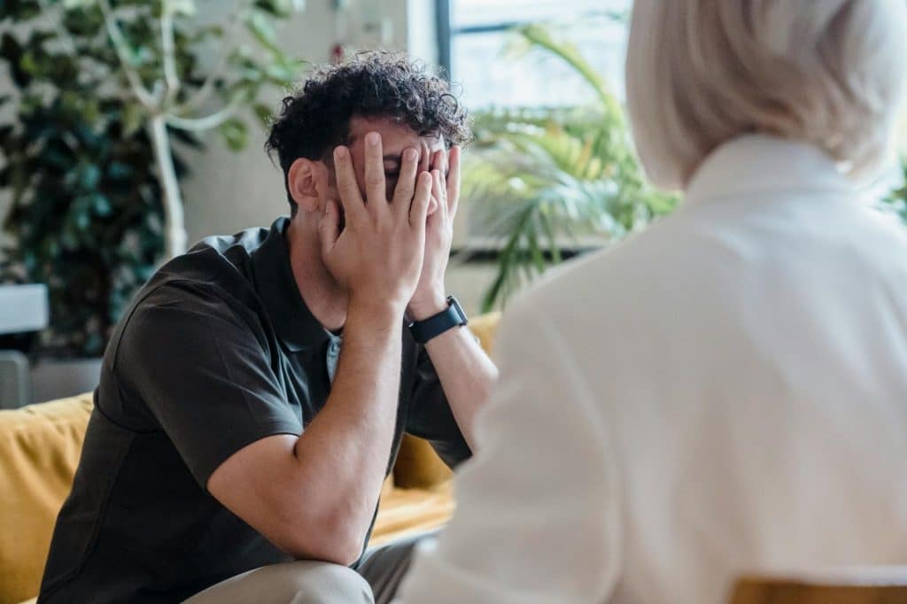 A man covering his face