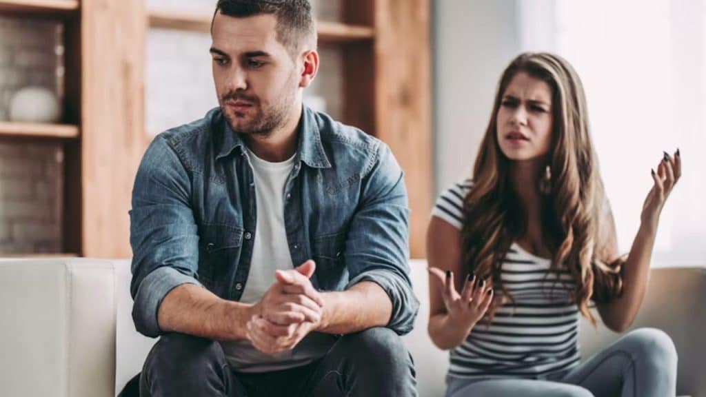 A woman looking frustrated while her husband speaks