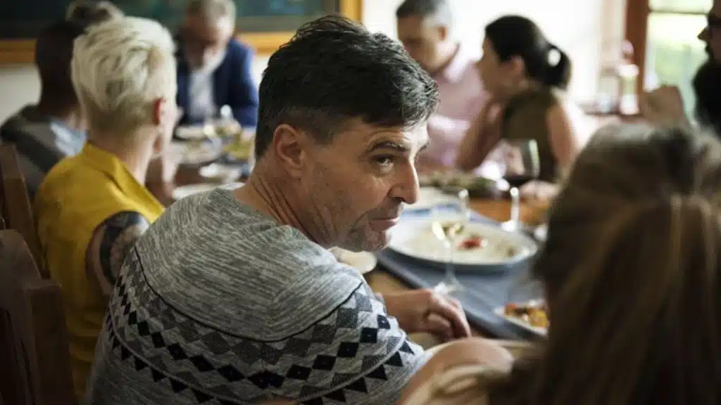 Man criticizing wife in front of friends at dinner