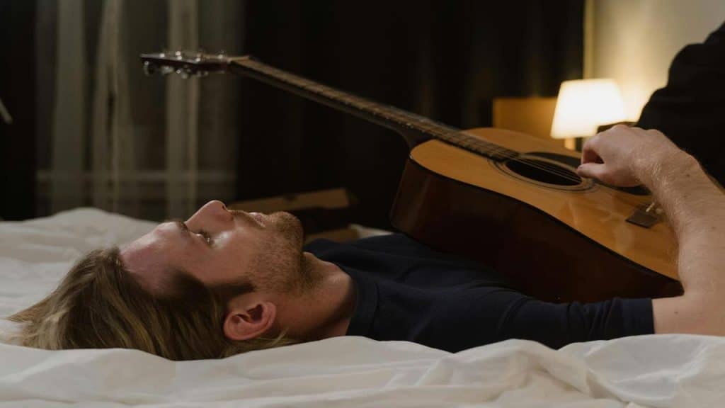 A man sad while playing guitar