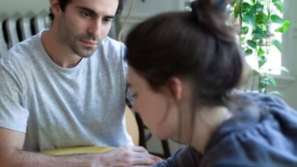 Couple sitting apart in silence after disagreement