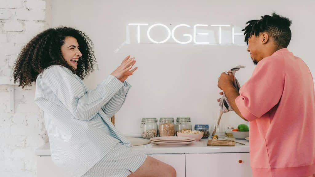A couple laughing together in the kitchen