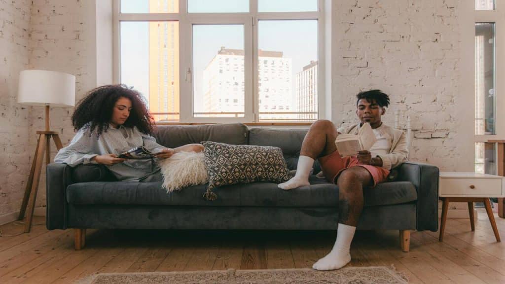 A couple ignoring each other in the living room
