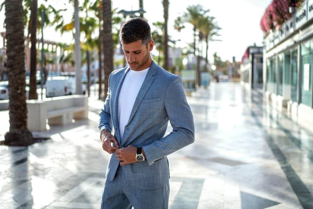 The man wearing a suit is walking on the street.