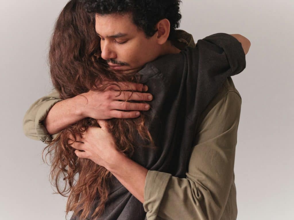 The man hugs the woman.