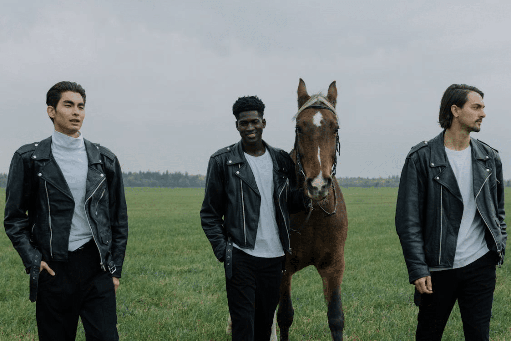 Men Walking on a Grassy Field with a Horse