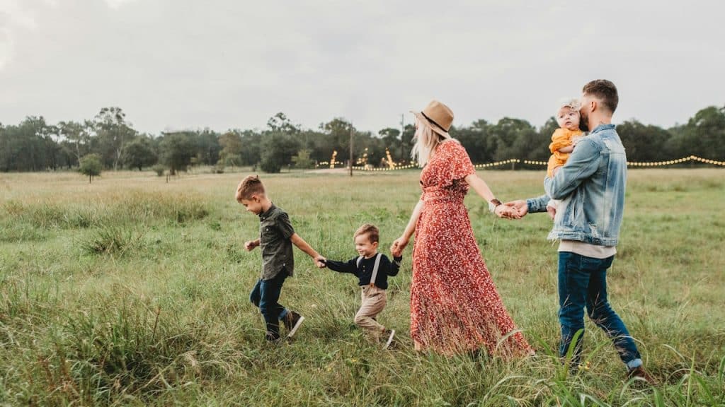 A happy family walking through a field.