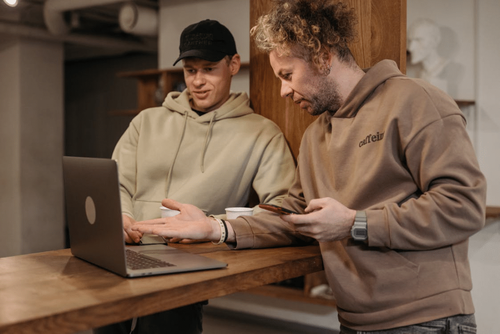 Men Wearing Hoodie Sweater Looking at the Laptop