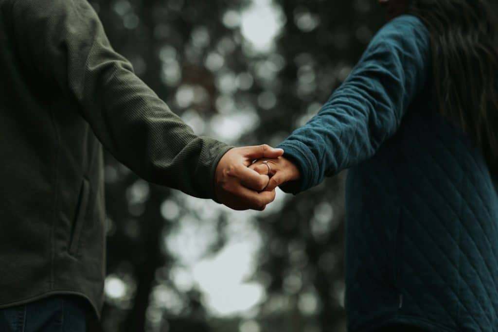 A close up of two people holding hands.