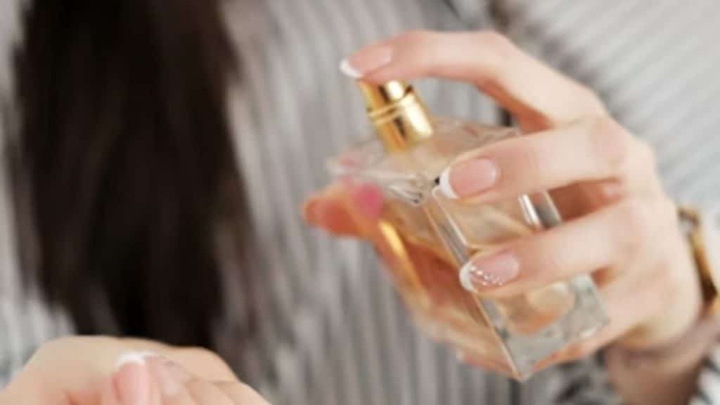 A woman applying perfume to her wrist