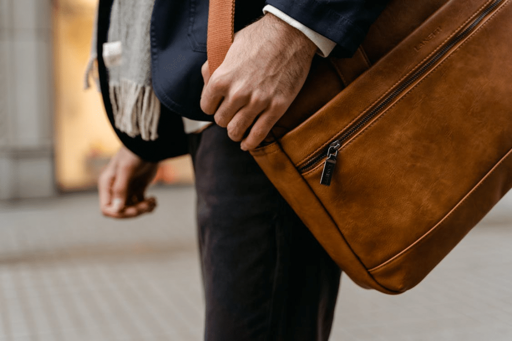 Person in Blue Long Sleeve Shirt and Brown Sling Bag
