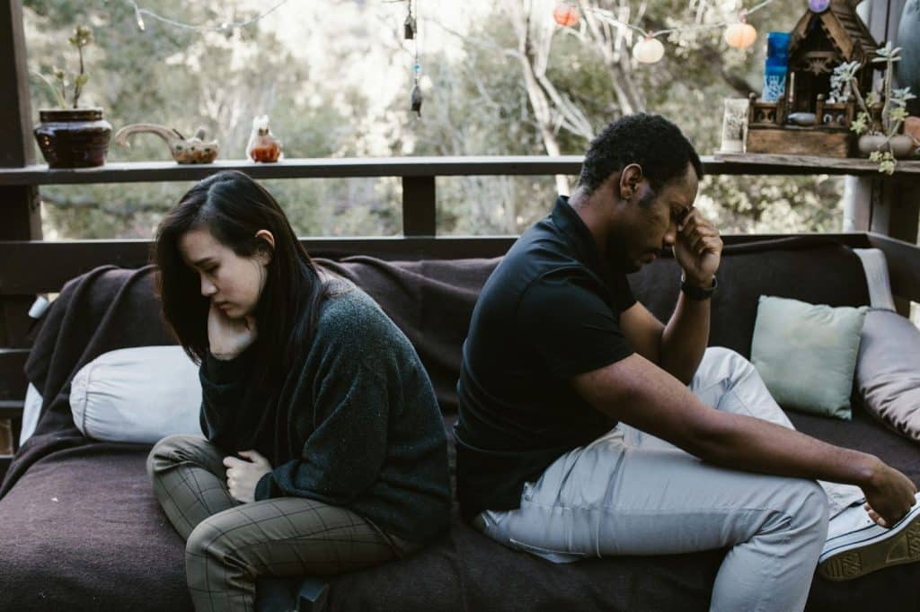 A man and woman sitting back to back