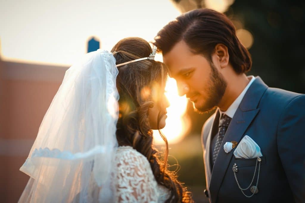 A man and woman in wedding dress and intensely looking at each other.