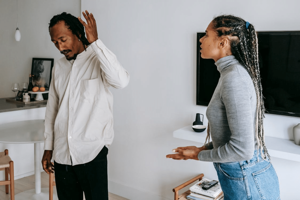 Unhappy young black couple discussing relationships at home