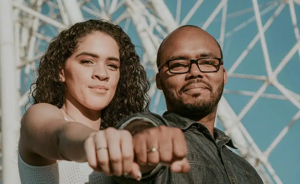 A couple showing their ring in front of the camera.