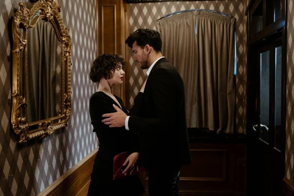 A well dressed couple intensely looking at each other.