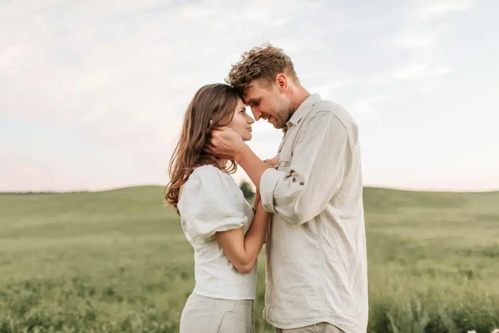 The couple is staring at each other in the middle of the field.