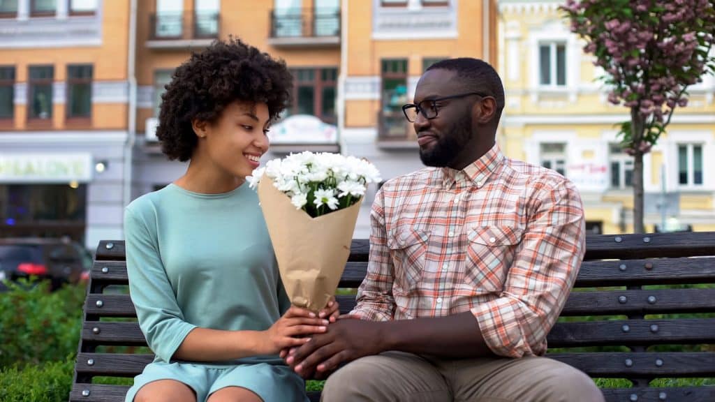 The man is giving the woman a bouquet.
