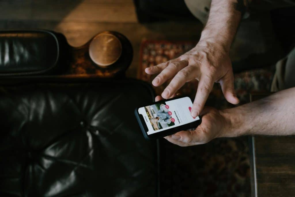 The man is using his smartphone.