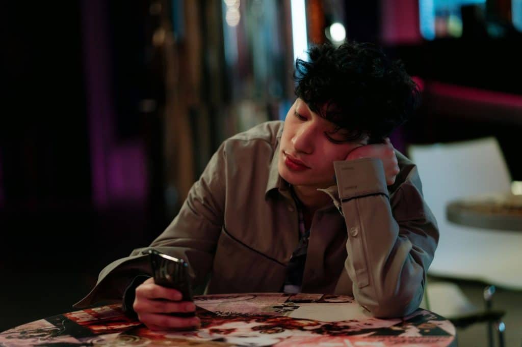 A man thinking while using a phone