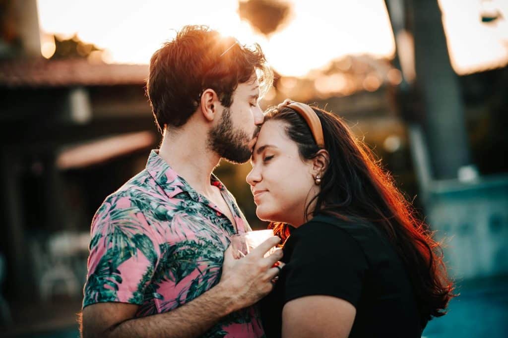 A man kissing a woman’s forehead