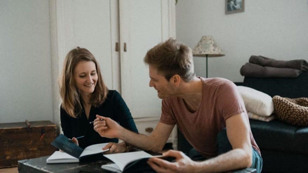 Man helping his partner plan finances at home