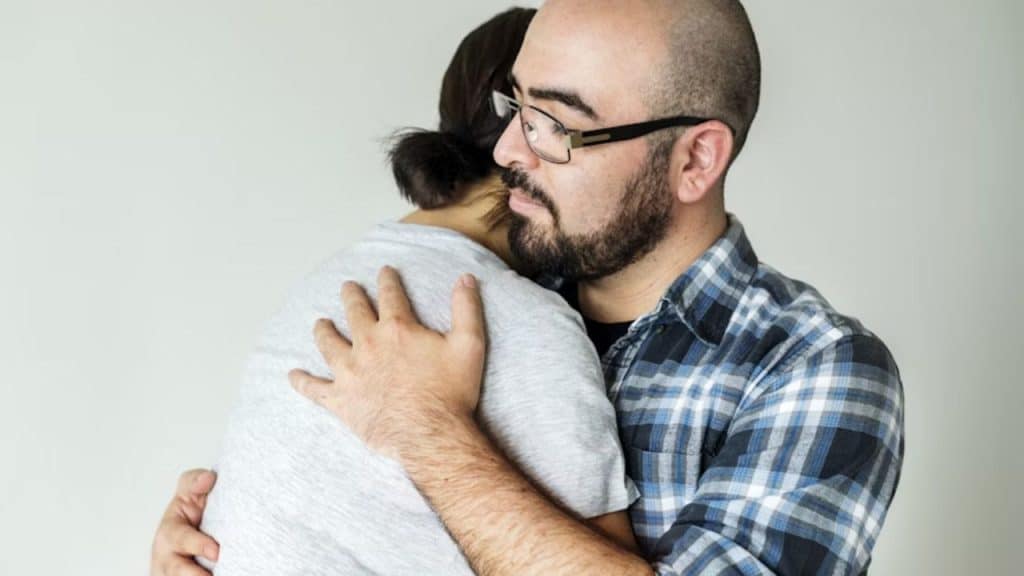 Man comforting his partner during a tough moment.
