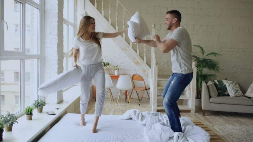 Couple laughing during a playful pillow fight