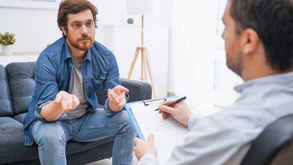 Man talking with a therapist in a modern office setting, relaxed mood