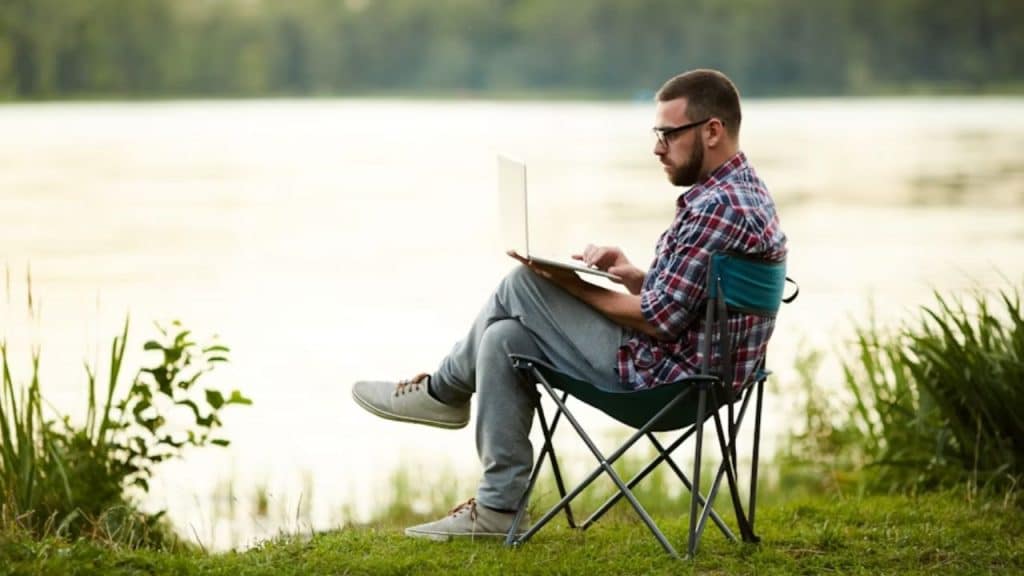Man journaling outdoors near the lake